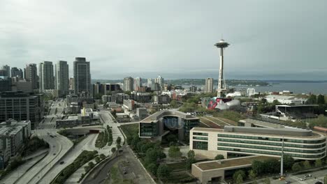 Cloudy-day-over-iconic-Seattle-skyline-and-waterfront-in-the-distance,-aerial-track