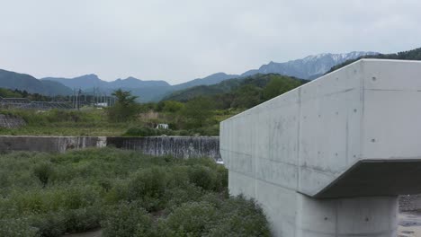 Construcción-De-Carreteras-Sobre-El-Río-Con-Mt-Daisen-En-El-Fondo,-Japón