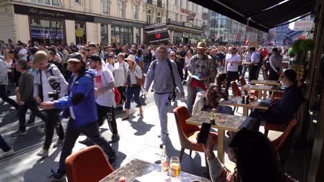 Menschen,-Die-Vor-Einem-Restaurant-Essen,-Beobachten-Demonstranten,-Die-Entlang-Der-Oxford-Street-Gegen-Sperren-Und-Impfpässe-Marschieren
