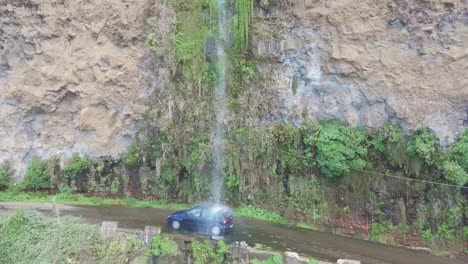Car-getting-a-free-car-wash-at-the-"road-waterfall"-in-Madeira