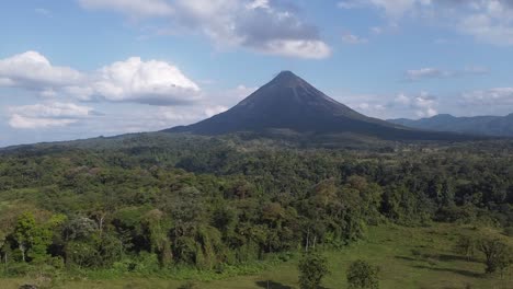 Aerial-over-rural-homes-and-dense-jungle-to-Arenal-Volcano-beyond