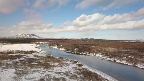 Cinematic-drone-shot-over-the-Olfusa-river-near-Selfoss-Iceland-with-mountains-in-the-distance