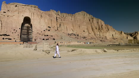 Mann,-Der-Auf-Einer-Straße-Mit-Blick-Auf-Die-Bamyan-buddha-stätte-In-Der-Ferne-In-Afghanistan-Geht---Weitwinkelaufnahme