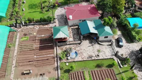 Aerial-View-Of-Farm-House-And-Cultivated-Land-Next-Door