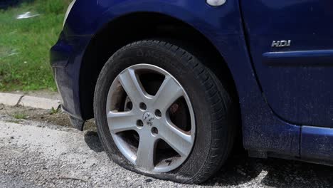 Close-up-slow-motion-shot-of-a-car-with-a-punctured-flat-tyre