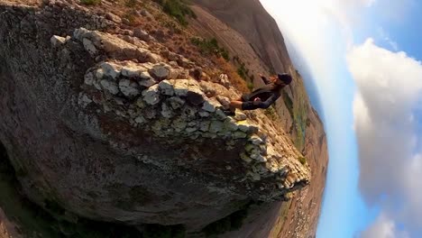 Vertical-360-footage-of-a-man-hiking-on-the-edge-of-a-cliff-in-Porto-Santo-Island