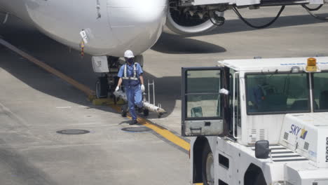 Ground-Workers-On-Airport-Tarmac-Preparing-To-Tow-A-Boeing-737-Passenger-Airplane-In-Tokyo,-Japan