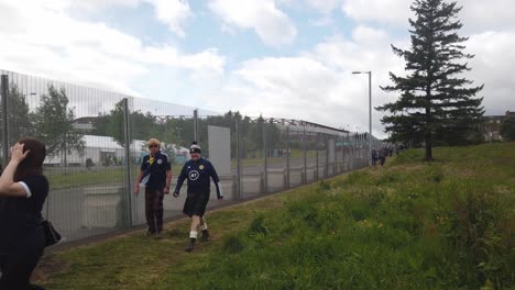 Smiling-Scotland-fans-walk-alongside-the-fence-to-get-into-Hampden-Park