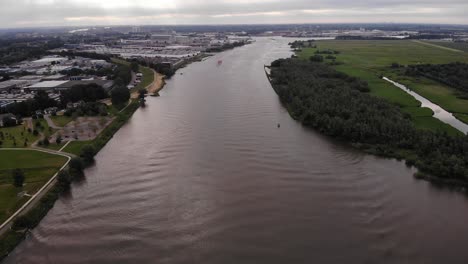 Aerial-Over-River-With-Trivor-Inland-Tanker-In-Background-Distance-In-Netherlands