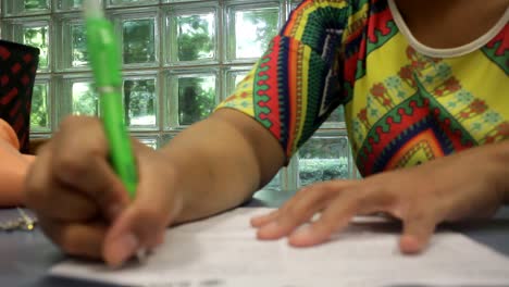 Primer-Plano-De-Una-Joven-Estudiante-Indonesia-En-La-Biblioteca-Estudiando-Y-Escribiendo