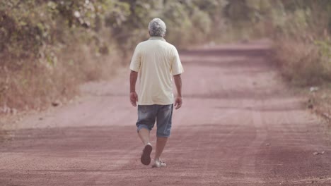 Un-Anciano-Caminando-Por-Un-Camino-De-Tierra-Rural