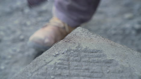 Handheld-shot-of-cancagua-stone-craftsman-using-a-chisel-to-shape-the-edge-of-a-stone-slab-in-the-city-of-Ancud-on-the-island-of-Chiloe