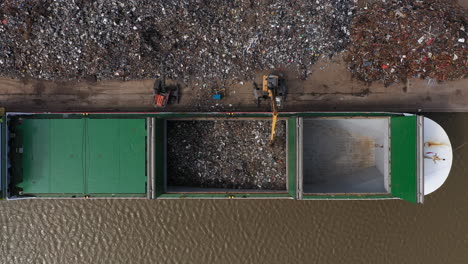 Birdseye-footage-of-scrap-metal-being-loaded-onto-a-large-ship-to-be-taken-for-recycling