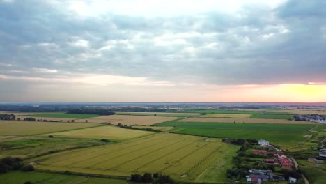 Aerial-over-British-countryside-landscape-with-farmland-and-fields-at-sunset