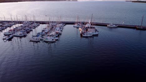 Barcos-De-Vela,-Vista-Superior-En-El-Puerto-Deportivo,-Atracados-En-El-Muelle-Durante-La-Puesta-De-Sol-12