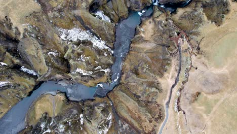 Drone-rotating-flying-over-winding-River-Canyon-in-Southern-Iceland-Countryside-off-Iceland-Ring-Road