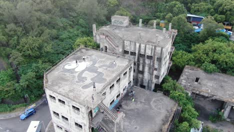 Hongkonger-Einheimische-Auf-Einem-Verlassenen-Industriedach,-Das-Mit-Einem-Großen-Graffiti-Von-Felix-Der-Katze-Geschmückt-Ist,-Luftbild