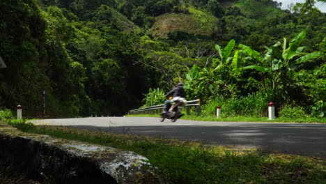 Turistas-En-Motocicleta-Recorriendo-La-Avenida-Ridge-En-Las-Montañas-Cerca-De-Phan-Rang,-Da-Lat-Durante-El-Verano-Con-Paredes-De-Piedra-Y-árboles-Verdes-A-Su-Alrededor