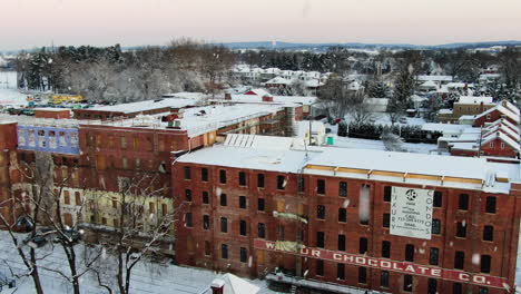 AERIAL-Snow-Falling-Over-Historic-Factory-Of-Lititz-Pennsylvania,-USA