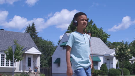 Young-african-american-boy-walking-down-street-with-headphones
