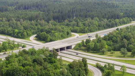 Timelapse-of-fast-driving-cars-at-a-german-highway-with-curved-exit-lanes-and-a-slow-zoom-out,-filmed-by-a-drone-from-above