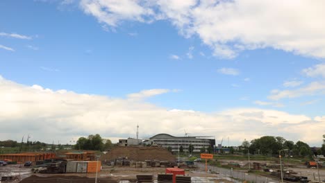 Thick-clouds-with-fluffy-cumulus-clouds-passing-by-over-a-construction-site-with-cumulus-cloud-forming-and-dissipating-and-rainfall-in-time-lapse-speed