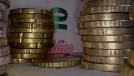 Dolly-zoom-out-showing-ten-euro-banknote-and-stack-of-coins,close-up