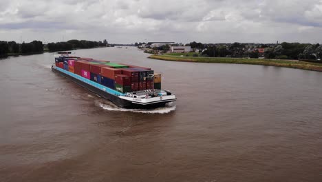 Aerial-Of-Ivernia-Cargo-Ship-Moving-Along-River-Noord