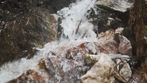Slow-Motion-Close-Up-Shot-Of-Water-Running-Over-Rocks---Boom-Shot