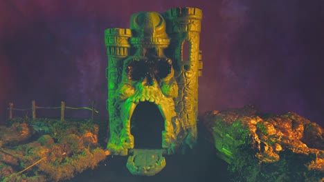Set-design-with-miniature-gray-skull-castle-against-foggy-night-sky-with-surreal-lighting