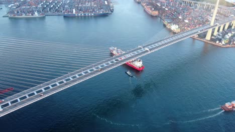 Großes-Containerschiff,-Das-Die-Bucht-Von-Hongkong-Unter-Der-Steinmetzbrücke-Verlässt,-Luftbild