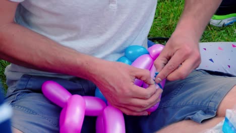 Balloon-artist-tying-balloons-in-park