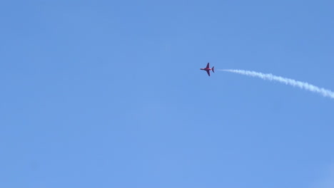 Red-arrows-jetfighter-flying-high-in-sky-leaving-white-smoke-trail-behind