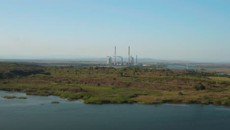 Fly-over-lake-with-coal-fired-electricity-power-plant-in-the-distance