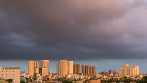 Day-to-night-time-lapse-with-urban-view-in-golden-light-with-dramatic-colorful-clouds-and-illuminated-buildings