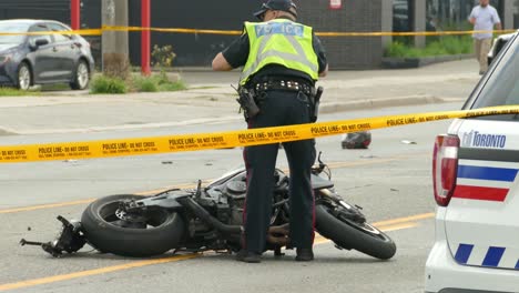 Motorrad-Crash-Szene-Mit-Gelbem-Klebeband-Bedeckt,-Während-Der-Polizist-Das-Fahrrad-überprüft