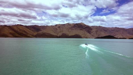 Toma-épica-De-Un-Hombre-Que-Disfruta-Montando-Su-Jet-Ski-A-Través-Del-Lago-Benmore,-El-Lago-Artificial-Más-Grande-De-Nueva-Zelanda