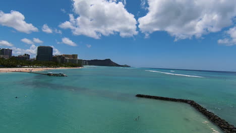 Flying-Over-Waikiki-in-Slow-Motion,-Drone-FPV-Shot-of-Gorgeous-Honolulu-Shoreline-on-Summer-Day