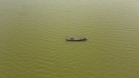 Aerial-footage-of-a-man-fishing,-turns-around-to-look-towards-the-drone,-Muak-Klek,-Saraburi,-Thailand
