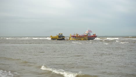Traktor-Mit-Anhänger,-Der-Ein-Knrm-rettungsboot-Im-Meer-In-Katwijk,-Niederlande,-Schleppt