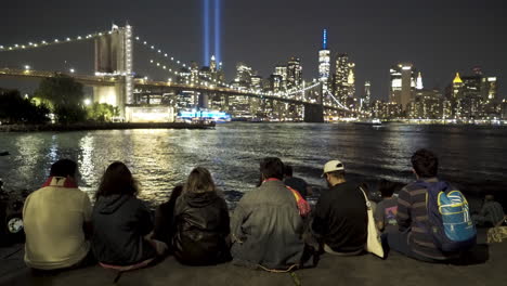 Group-Of-People-Sit-And-View-September-11th-Memorial-Lights-In-New-York-City