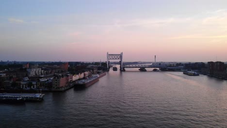 Bolero-Cargo-Ship-Entering-Dordrecht-Railway-Bridge-Against-Pink-Sunset-Skies-On-Oude-Maas