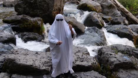 The-river-flows-behind-a-dancer-doing-a-social-media-trend-dressed-as-a-ghost