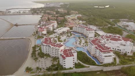 AERIAL---High-altitude-shot-of-a-hotel-in-Cancun,-Mexico,-circle-pan