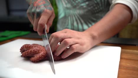 Chef-cutting-half-octopus-camera-follow-knife-slow-motion