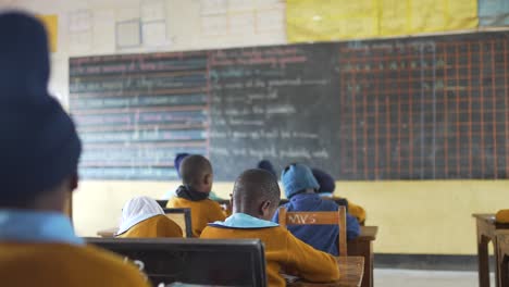 Afrikanische-Schule-Mit-Kindern,-Die-Unterricht-Machen-Und-Auf-Die-Tafel-Schauen