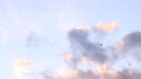 Distant-View-Of-The-Airplane-Flying-From-The-Sky-With-Colorful-Horizon-During-Sunset