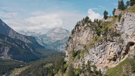 Drone-shot-along-mountainous-cliff-revealing-epic-mountain-view-Switzerland