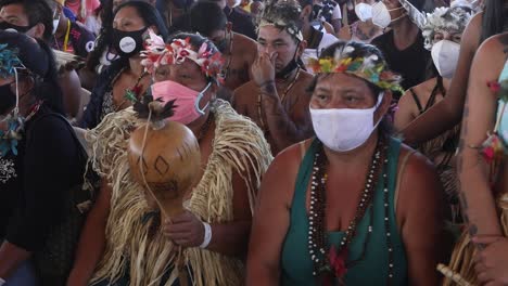Indigene-Stämme-Diskutieren-über-Die-Erhaltung-Des-Amazonas-Regenwaldes,-Während-Sie-Gesichtsmasken-Und-Traditionelle-Stammeskostüme-Tragen