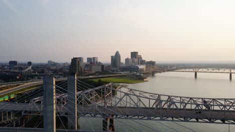 Aerial-view-of-interstate-65-and-64-and-the-Louisville-skyline,-sunny-evening-in-United-states---pan,-drone-shot